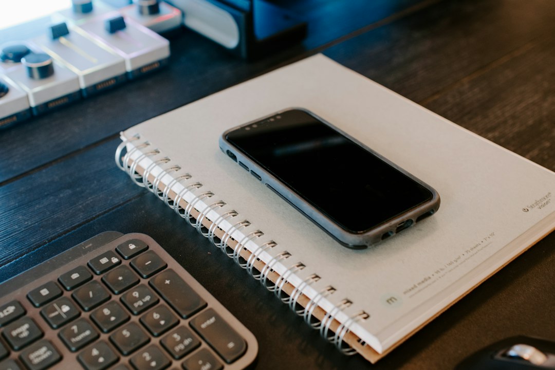 手書きのバレットジャーナルと習慣アプリを公平に比較 — ノートの上に置かれたスマートフォン
