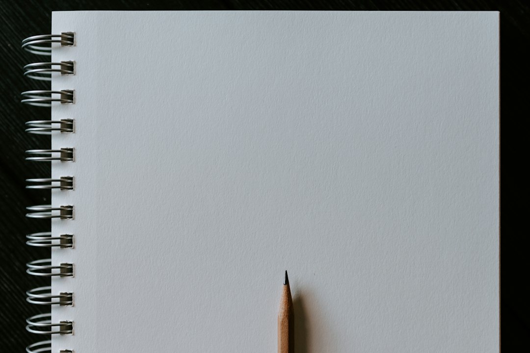 毎日イラストが続かない理由 — 白い机に置かれた鉛筆とスケッチブック