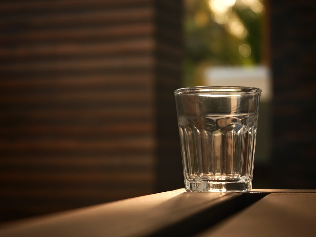 水が入ったコップが置かれた机 — 水を飲む習慣が続かない理由