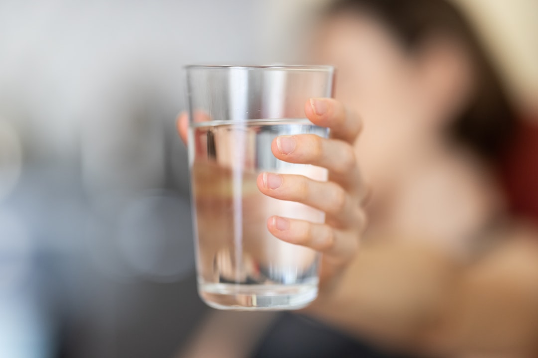水の入ったコップを手に持つ — 開発者が続ける朝の水の習慣