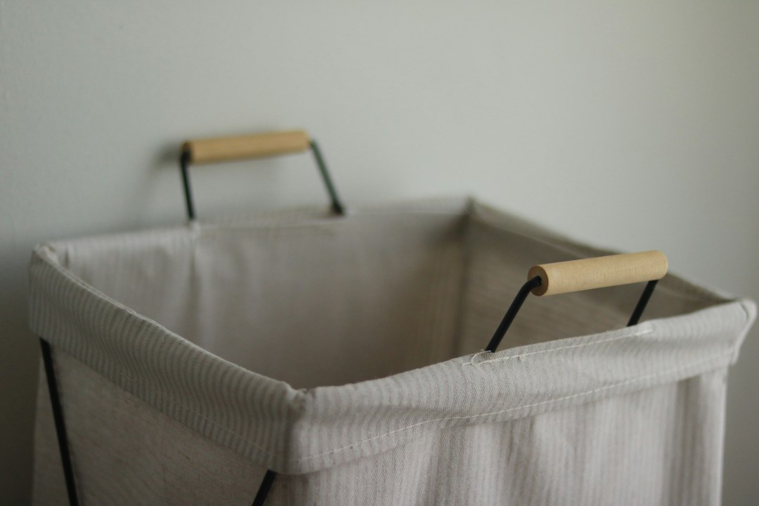 軽やかに家事を進める人のイメージ — 洗濯かごと片付いた部屋