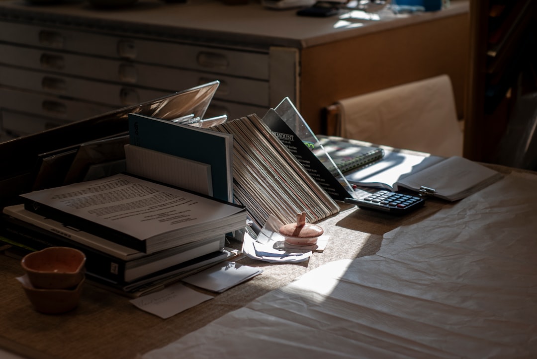 書類と電卓が積まれた机 — 家計簿が続かない理由
