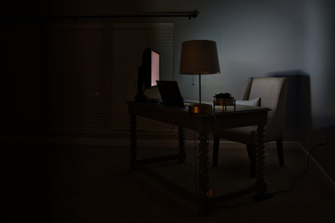 夜型の人のイメージ — 夜遅くにデスクのライトの下でノートPCに向かって集中する