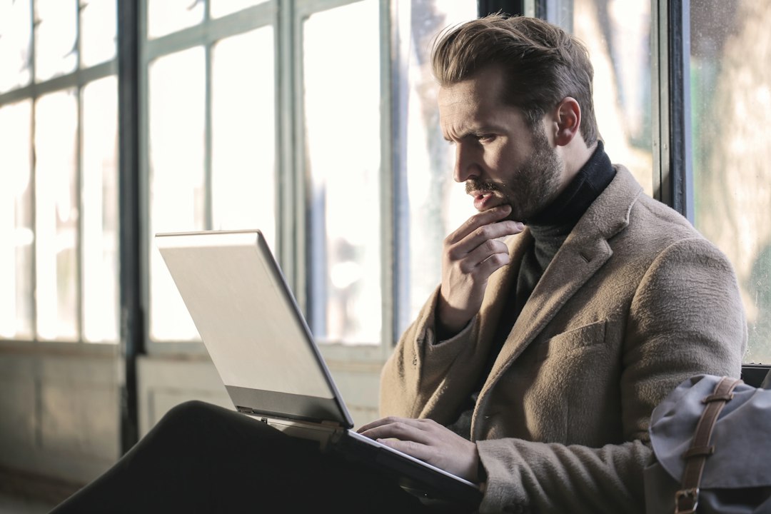 ノートパソコンの前で考える人 — Notion習慣トラッカーの向き不向きを見極めるイメージ