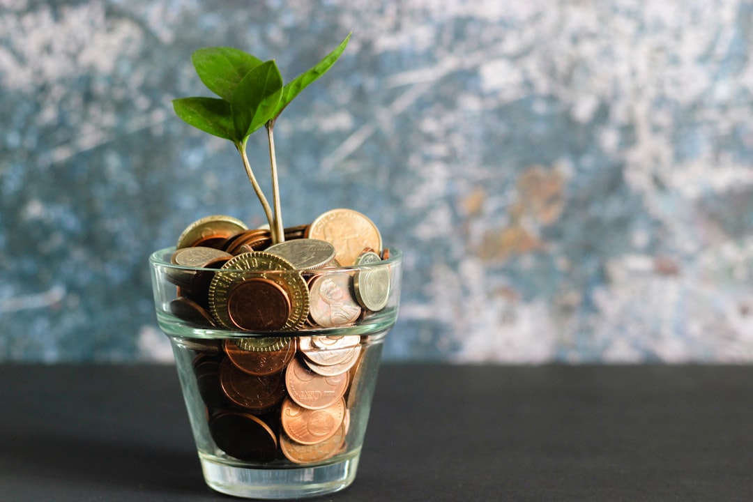 コインの入った瓶と育つ植物 — 報酬が遠い貯金や運動は現在バイアスに弱いことのイメージ