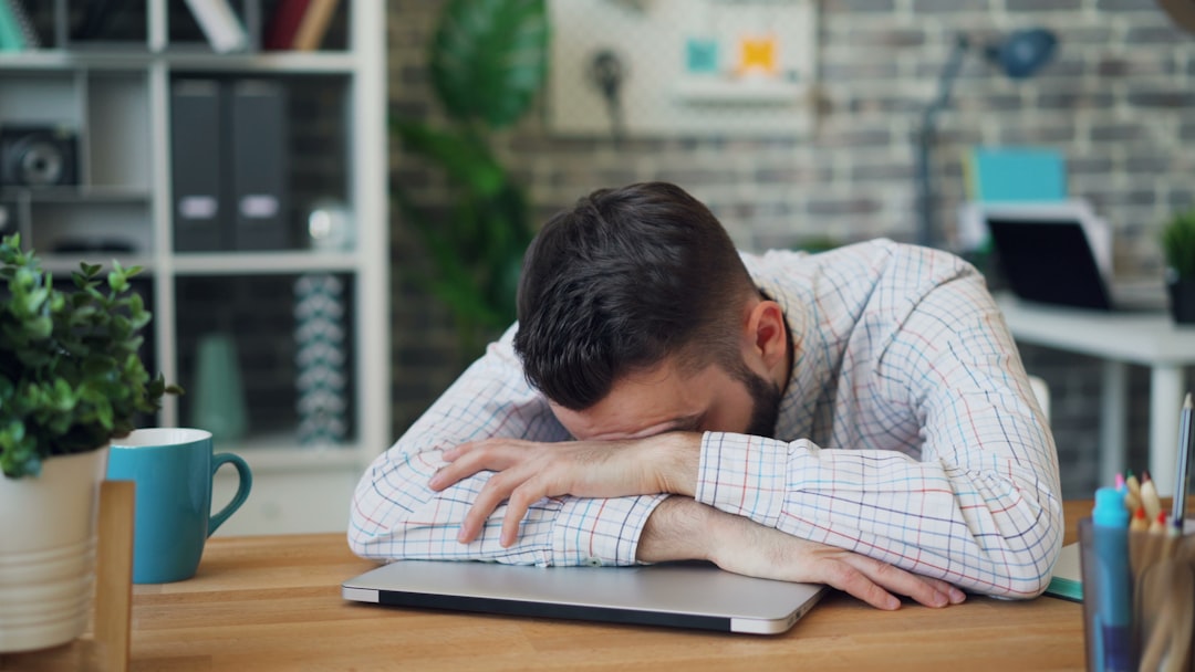 ルーティン表が続かないイメージ — 机で頭を抱えて行き詰まる人