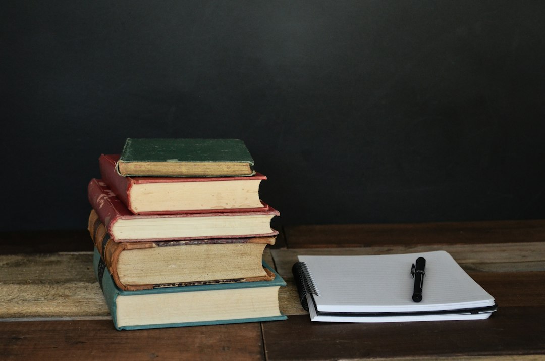 積み重なった本とノートとペン — 速読より毎日読む習慣が読む力を伸ばす