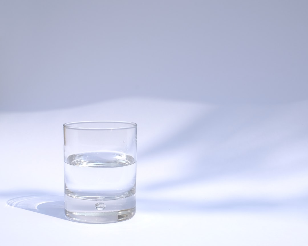 疲れない人がやっている習慣 — コップ一杯の水を置いた朝のテーブル
